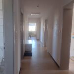 Blick in den Flur mit 7 sichtbaren Türen und Tageslicht