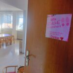 Blick ins Spielzimmer durch die offene Tür, dahinter Fenster, Arbeitstische, Schaukelpferd